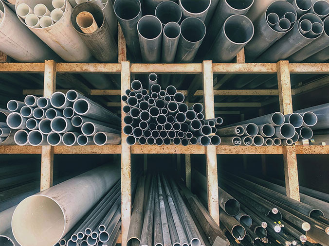 Steel and PVC plumbing pipes in a plumbing supply warehouse